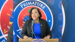 Niola Lynn Sarah Devalis Octavius, Ministre de la Jeunesse, des Sports et de l’Action civique et le drapeau haïtien. (Photo publiée par @PrimatureHT)