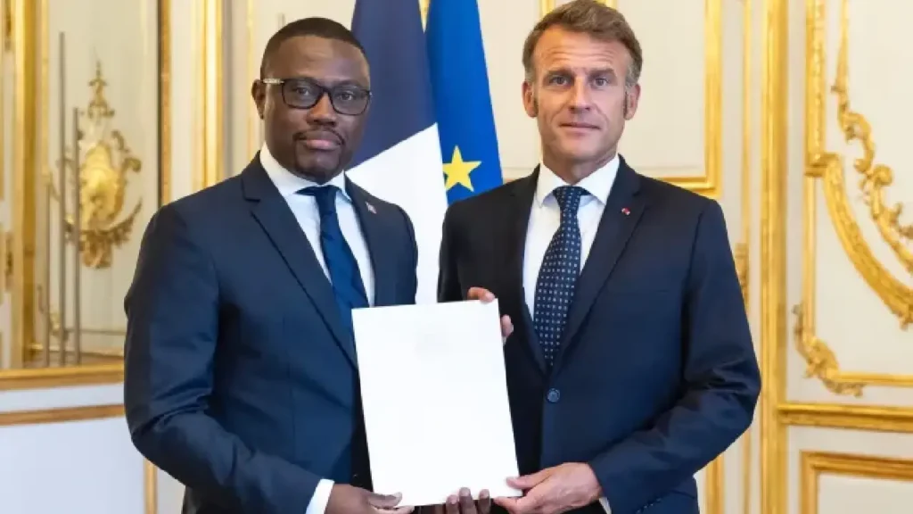 A gauche, le diplomate haitien, Louino Volcy, à droite, le président français, Emmanuel Macron