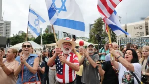 Des personnes célèbrent l'annonce d'un accord de cessez-le-feu entre Israël et le Hamas sur la place des Otages à Tel Aviv, en Israël. [KEYSTONE - ABIR SULTAN]