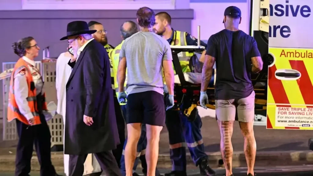 Des ambulanciers prennent en charge une victime après la fusillade survenue sur la plage de Bondi, à Sydney (Australie), le 14 décembre 2025. (SAEED KHAN / AFP