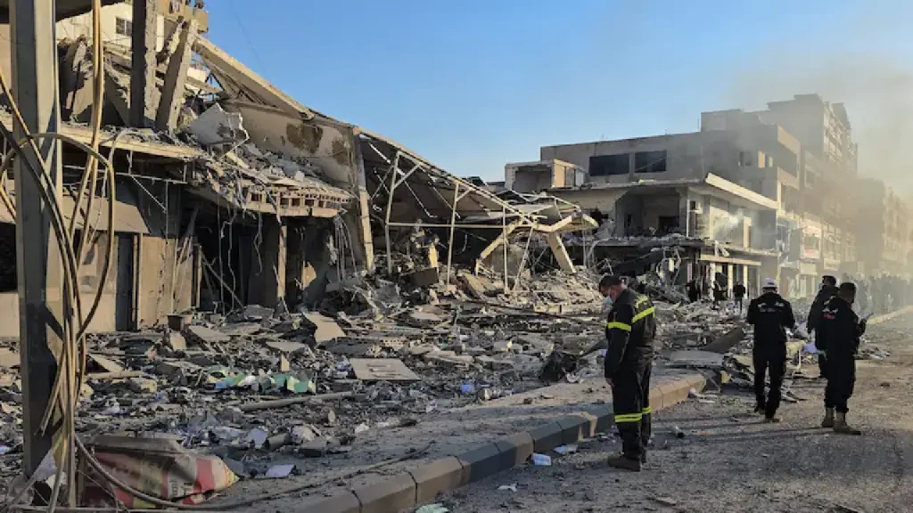 Des secouristes inspectent un site touché par une frappe israélienne, à Tyr, lundi. (Kawnat Haju/AFP)